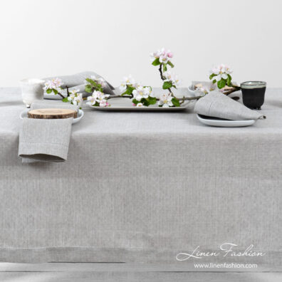 Light grey pure linen tablecloth in a small openwork pattern, and decorated with a row of hemstitch along its edges