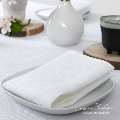 Playfully patterned optical white napkin made from medium weight linen / cotton fabric