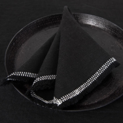 black linen napkin with decorative stitch.