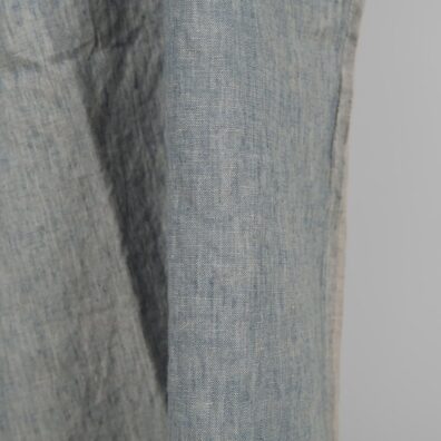 Linen washed fabric grayish blue color for sewing clothes and home textiles close edge view