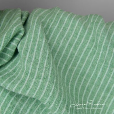 Wide washed green striped linen fabric close up detail view