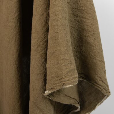 Wide washed linen fabric moss brown colour close view of edge
