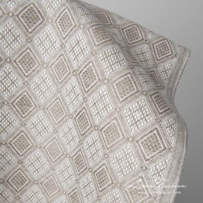 Linen cotton fabric sand colour rhombus pattern close up edge view