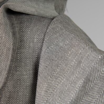 Linen fabric greyish brown in herringbone pattern close up detail