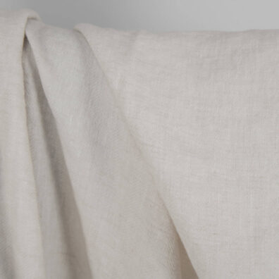 Washed linen wool fabric beige in herringbone pattern close up detail