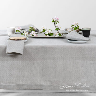 Light grey pure linen tablecloth in a small openwork pattern, and decorated with a row of hemstitch along its edges