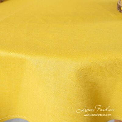 Yellow colored tablecloth, round.