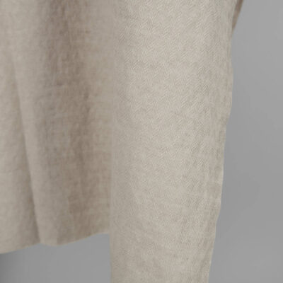 Washed linen cotton sand colour herringbone pattern close up edge view