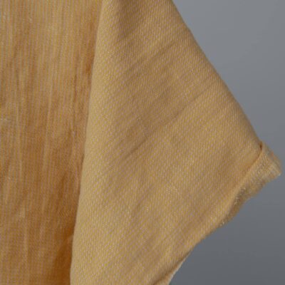 Washed linen cotton fabric in yellow-sand small pattern edge view