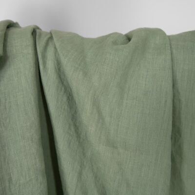 Washed linen fabric in muted light green, plain weave