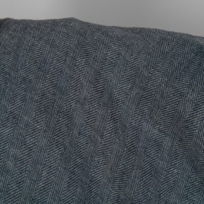 Washed linen wool fabric black white in herringbone pattern close up detail