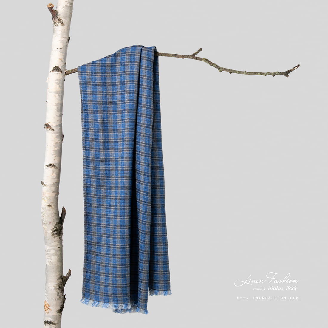 Blue linen shawl with checks on tree.