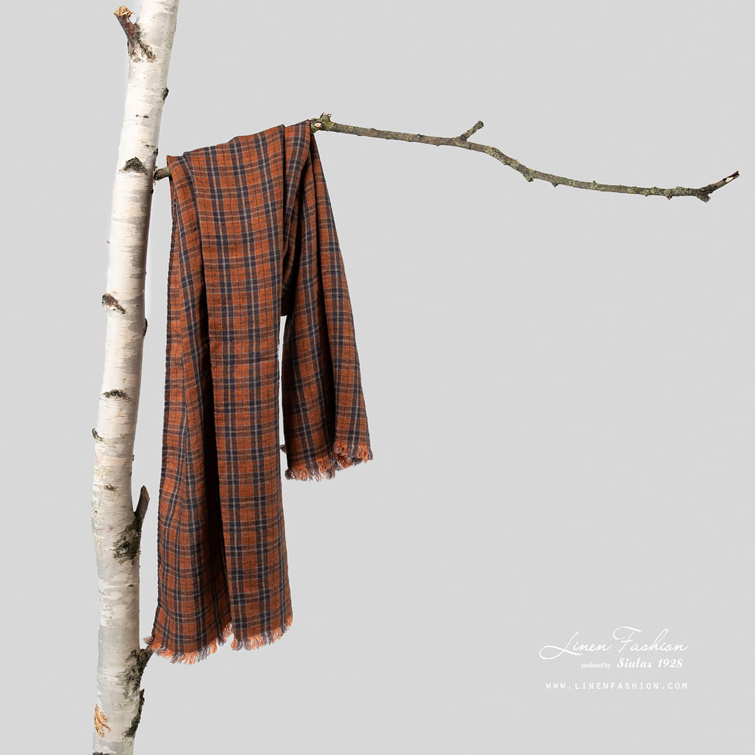 Brown linen shawl with checks on tree.
