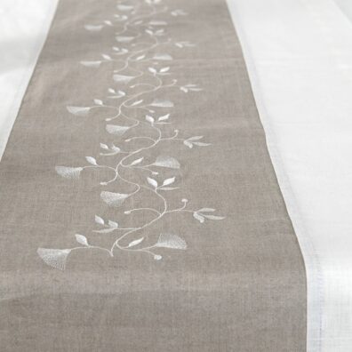 Off-white table runner with natural linen middle, with floral stitching